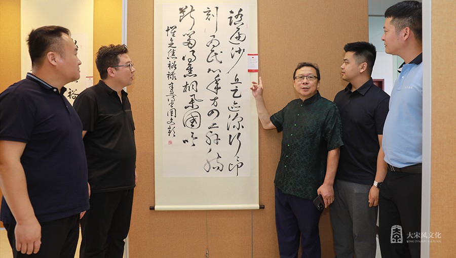 策展人黄斌向部分致公党党员讲解参展作品